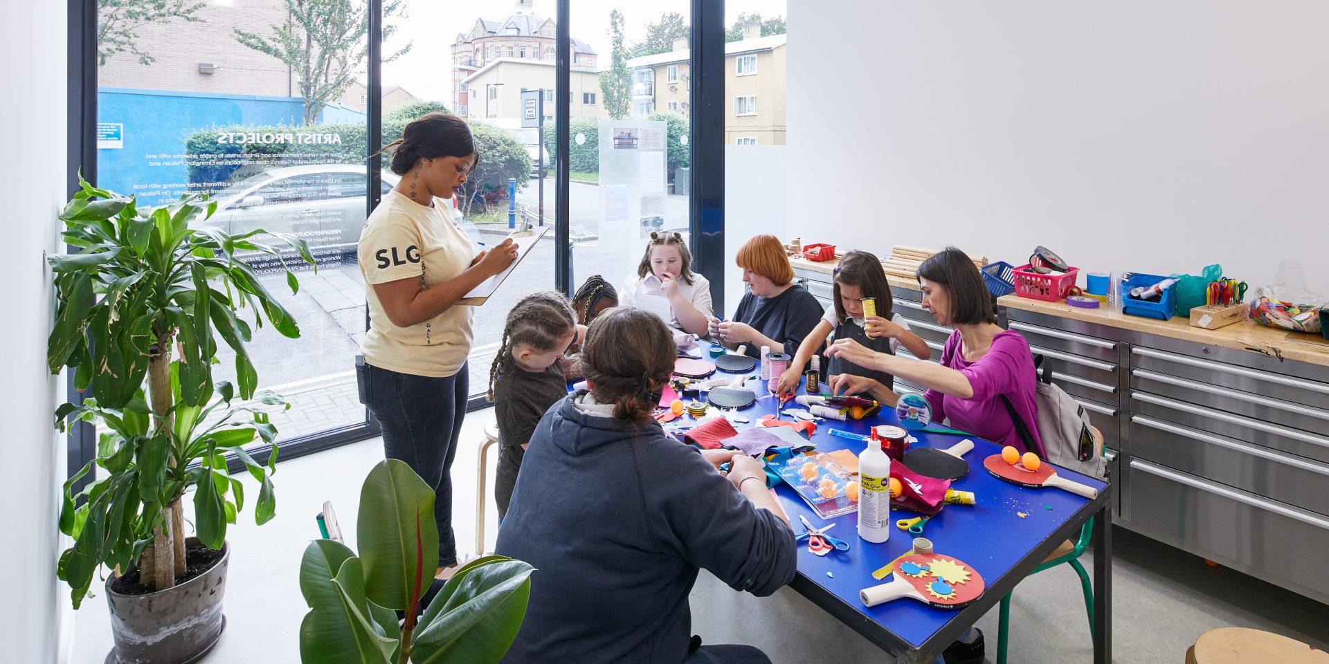 Children round a table working together to make things with coloured materials