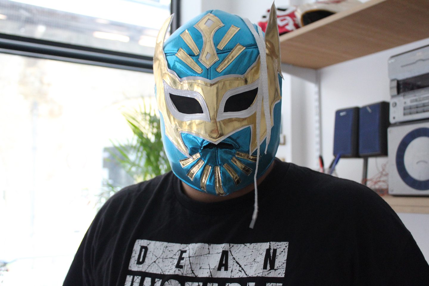 Art Assassin Mehmet Cucel poses with a wrestling mask during a visit to Andrea Franke’s studio.