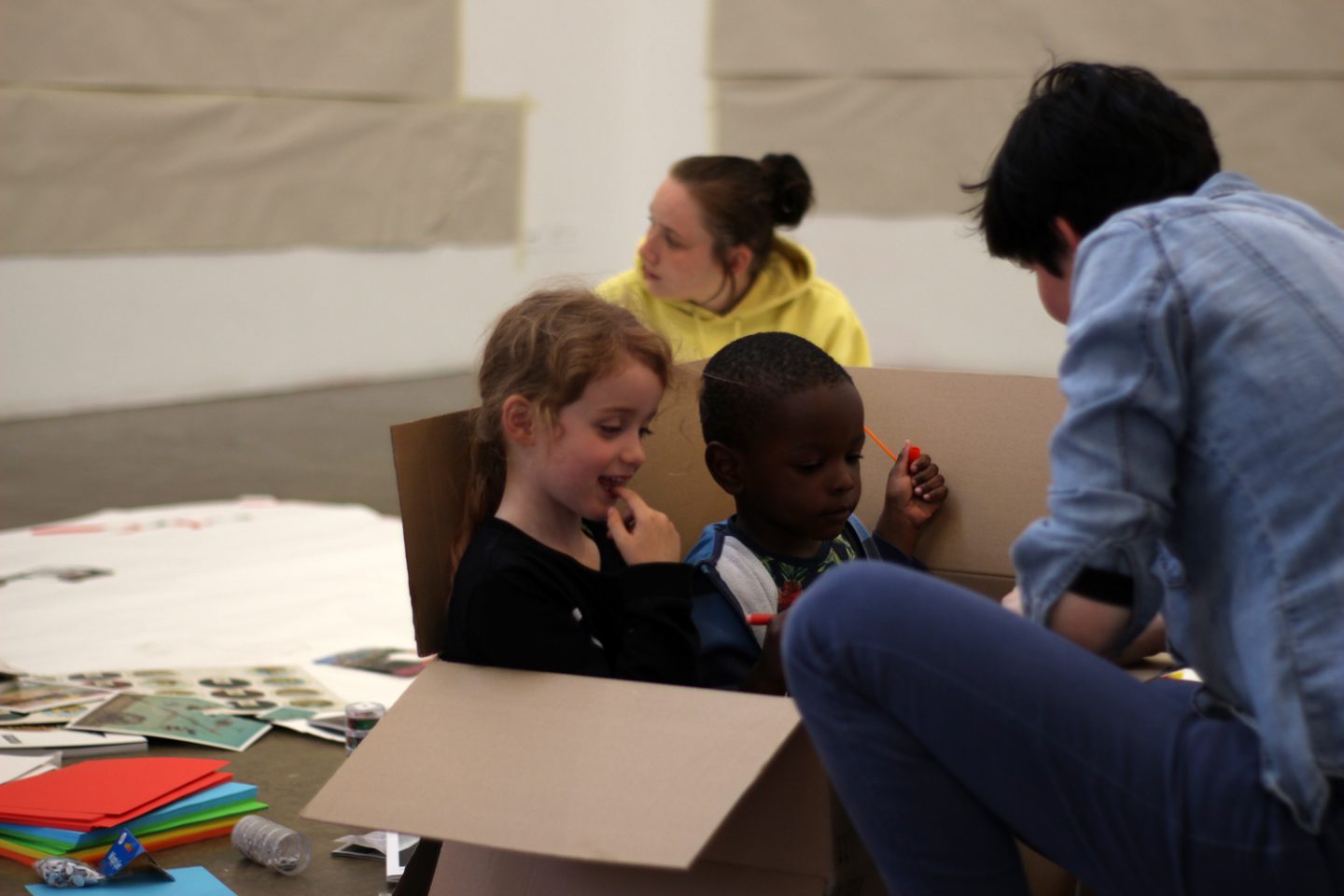 Sunday Spot workshop with Mai Omer, with two children playing in a box