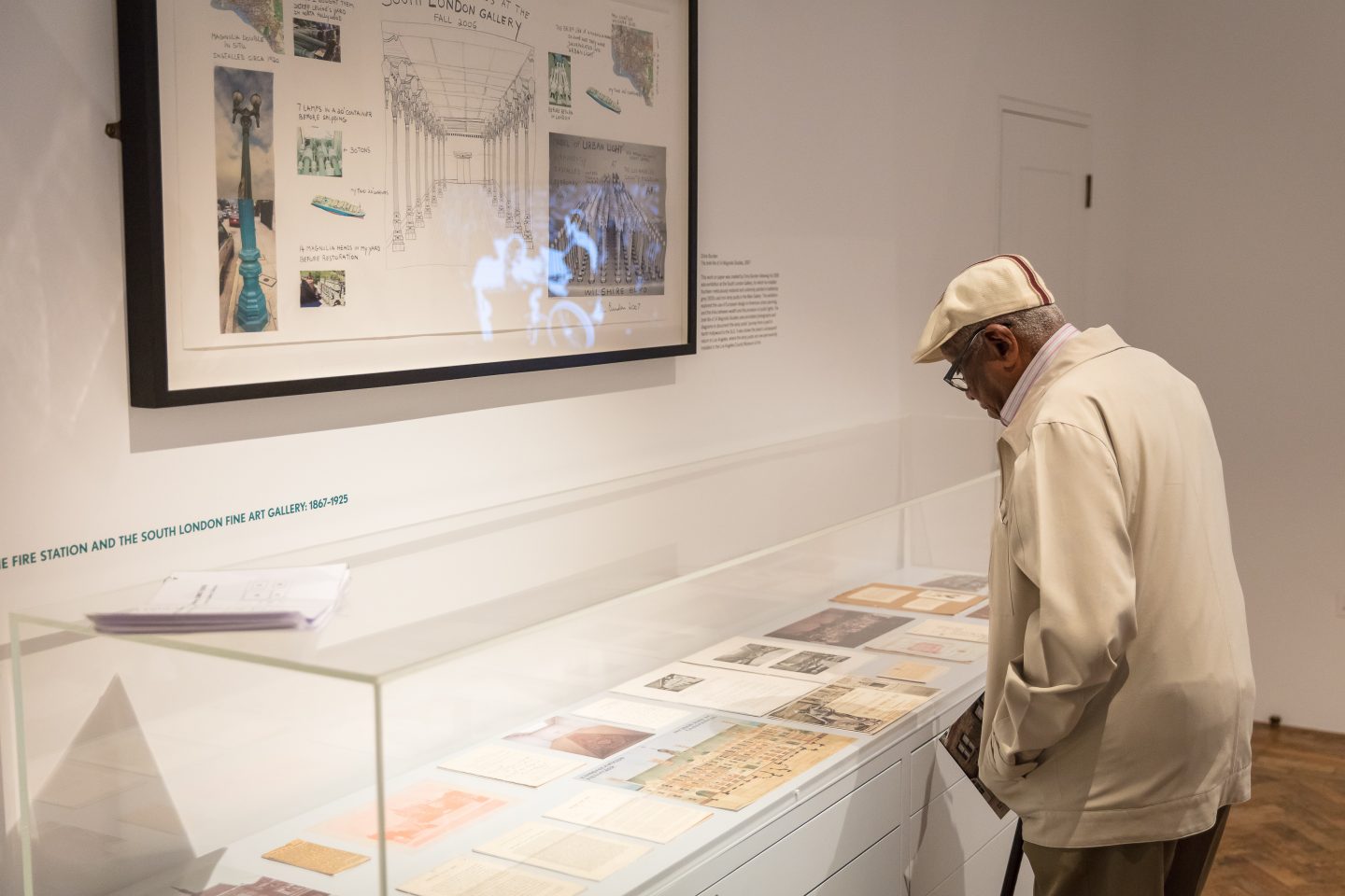 Man peers over a vitrine of archival material