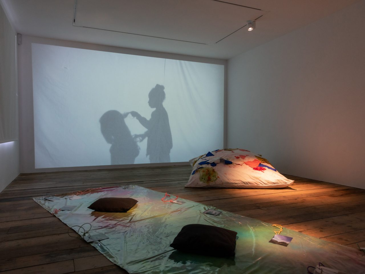 Gallery four with projection of two children, one combing another's hair