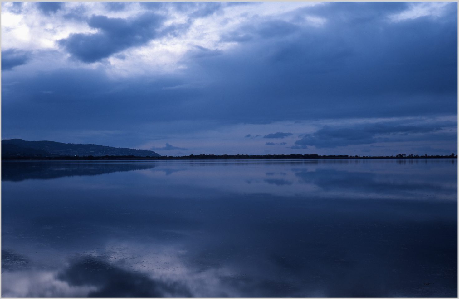 A blue view of a lake and the horizon