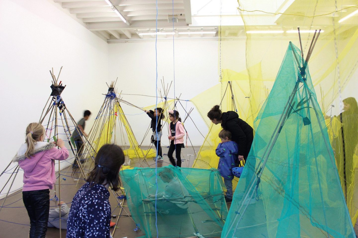 Children build tent like structures in a Sunday Spot workshop