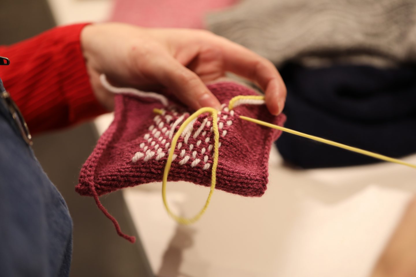 A hand holds fabrics whilst stitching it