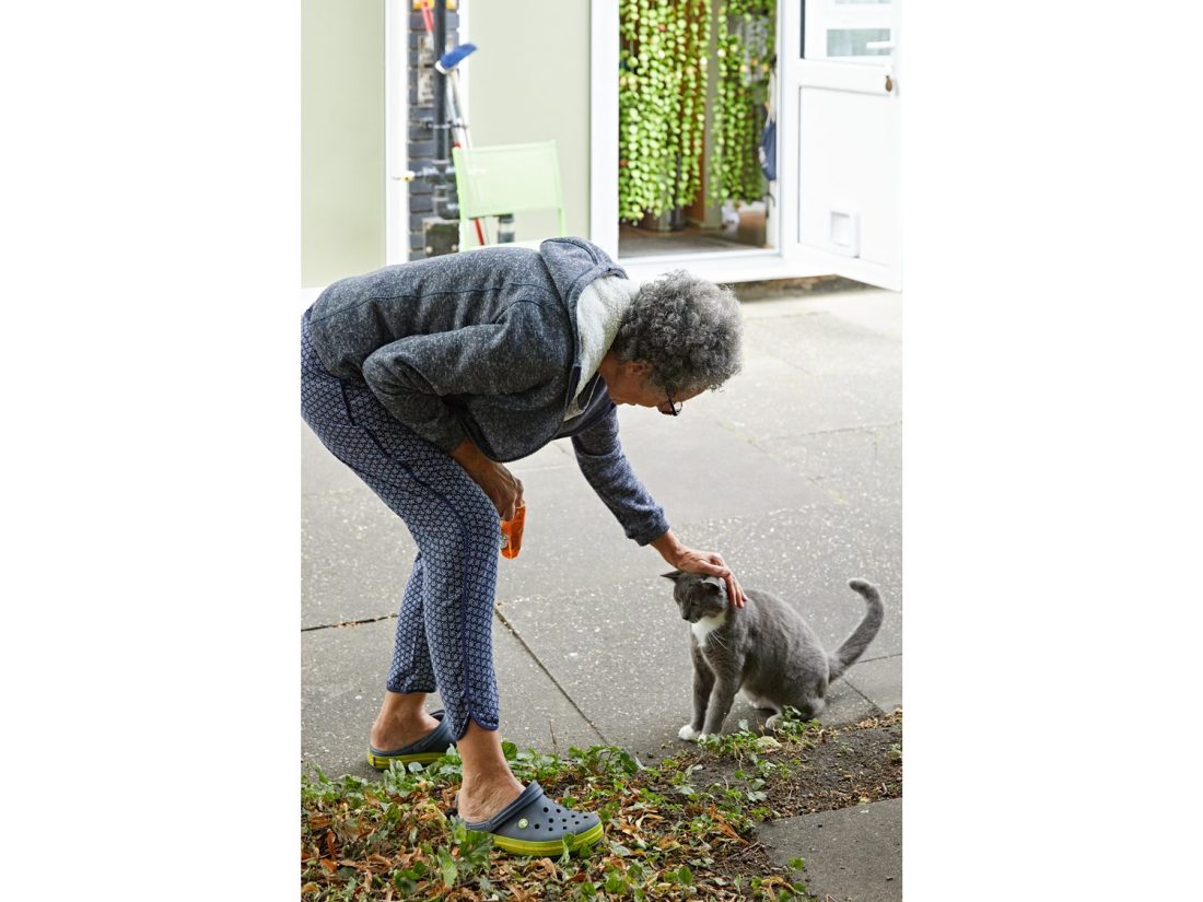 <p>Liz in the Sceaux Gardens community garden with Albert the cat. Photo: Andy Stagg</p>
