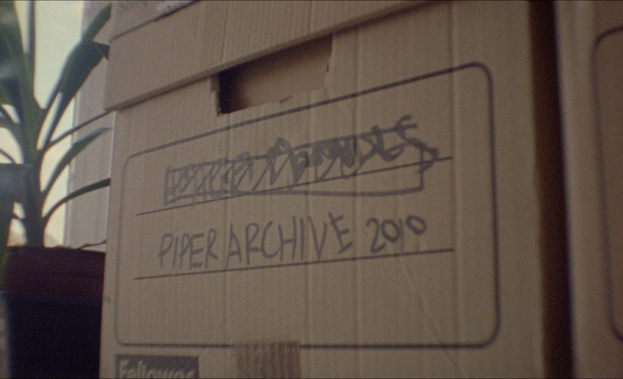 A brown cardboard box with 'Piper Archive 2010' scribbled on