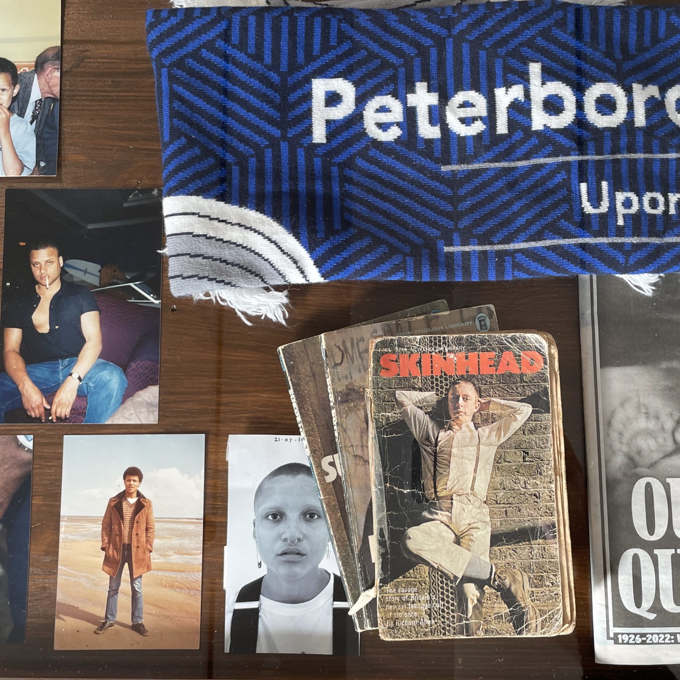 Photographs, books and a scarf lying on a wooden table