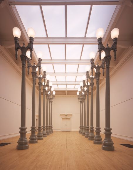 Image of 14 large lamps positioned on the side of the South London Gallery's main gallery. The art work is called 14 magnolia Doubles and it is made by the artist Chris Burden.