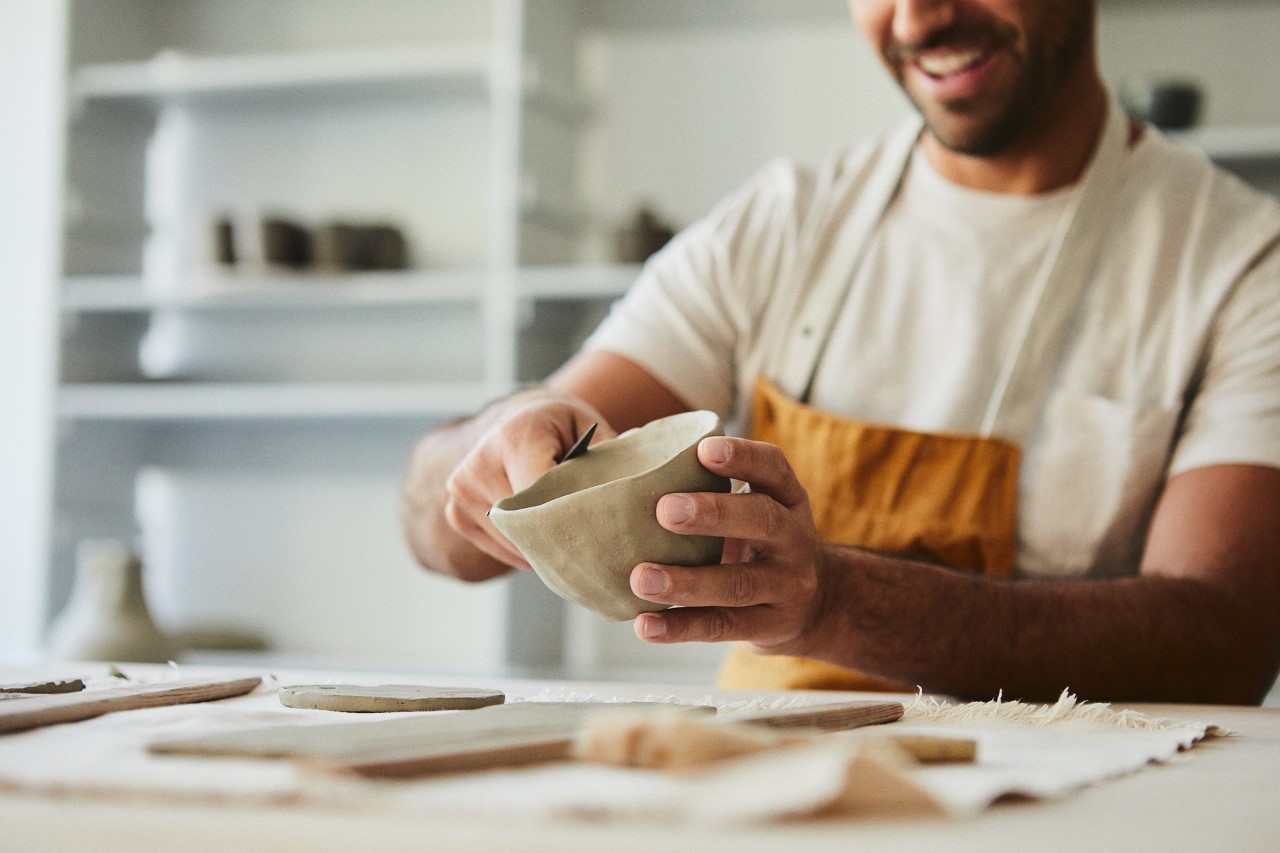 A man makes a pot out of clay