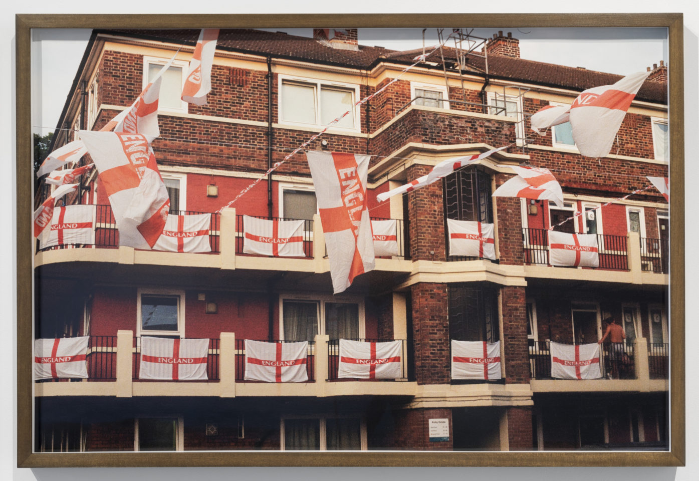 A photo of a council estate in South London with England's St George's flags hung around the building.