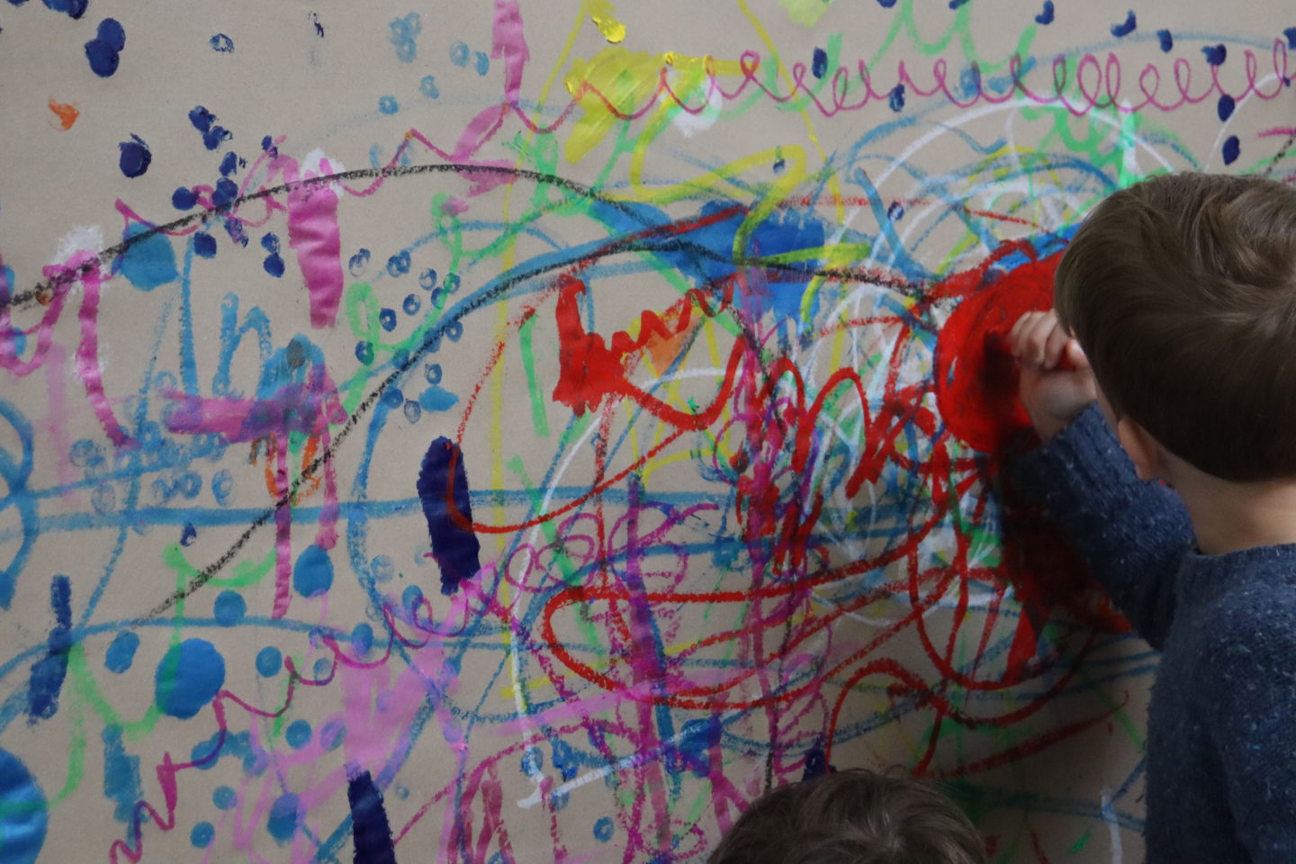 A child paints a bright colourful painting.