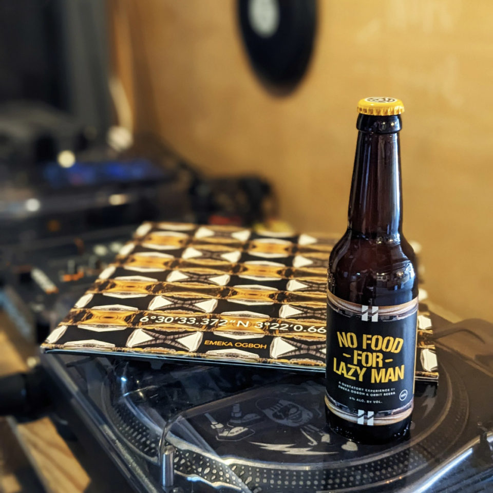 A bottle of beer sits on a record player.