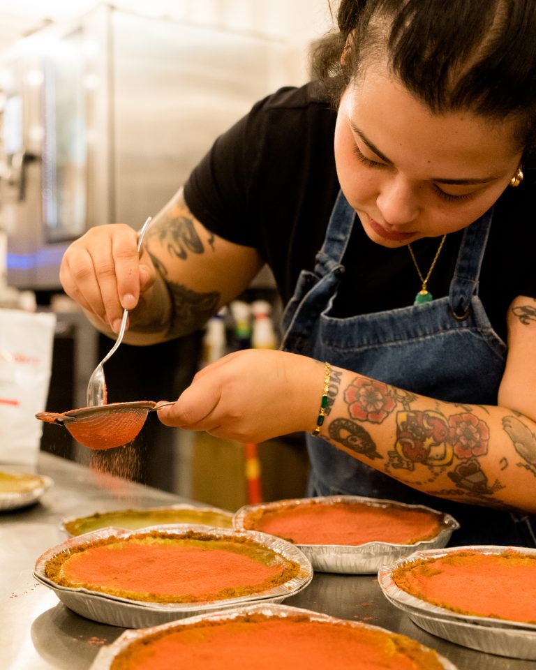 A chef puts the finishing touches on a dish in a kitchen