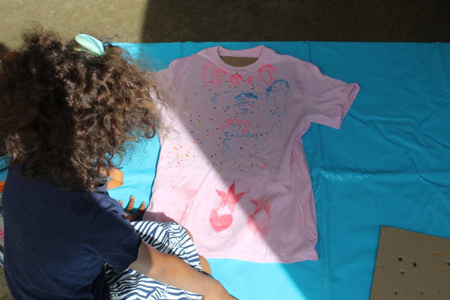 A child is designing their own t shirt in a creative workshop.