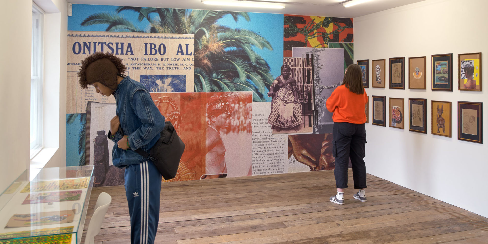 Two people in an art gallery looking at a colourful installation by artist Chiizii.