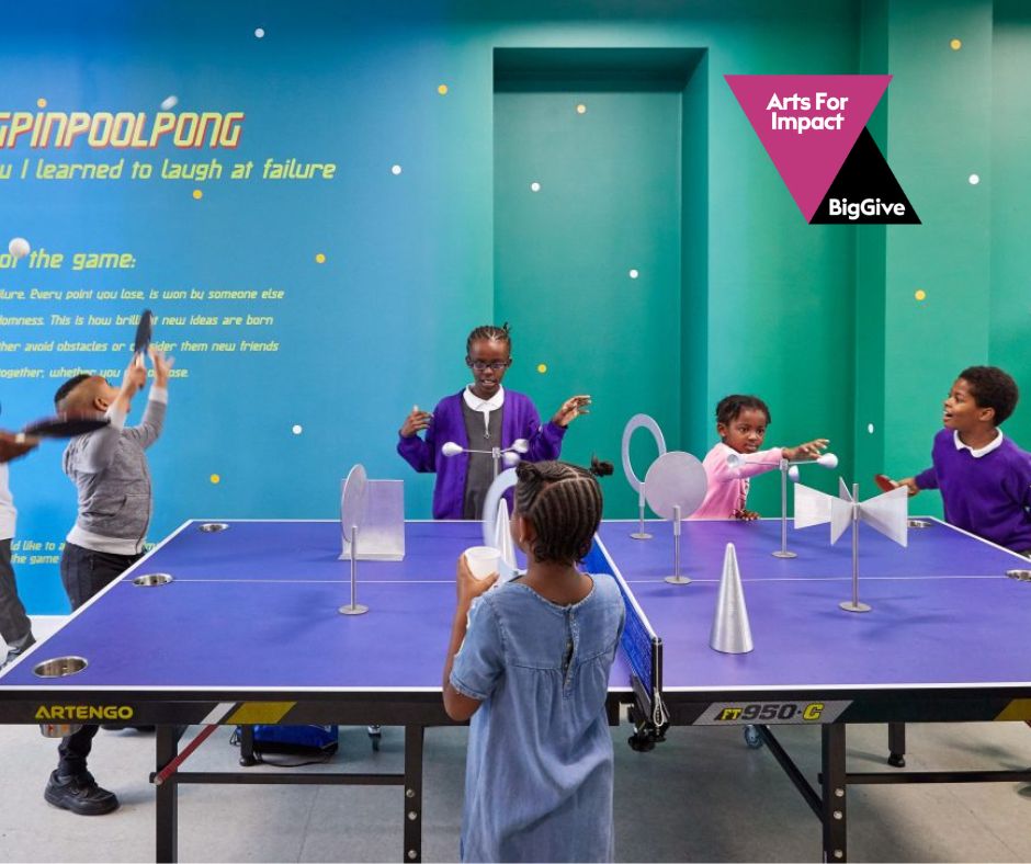 Children play ping pong in a bright blue room