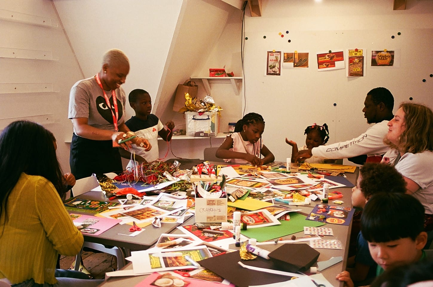 Children and adults in an art room collaging