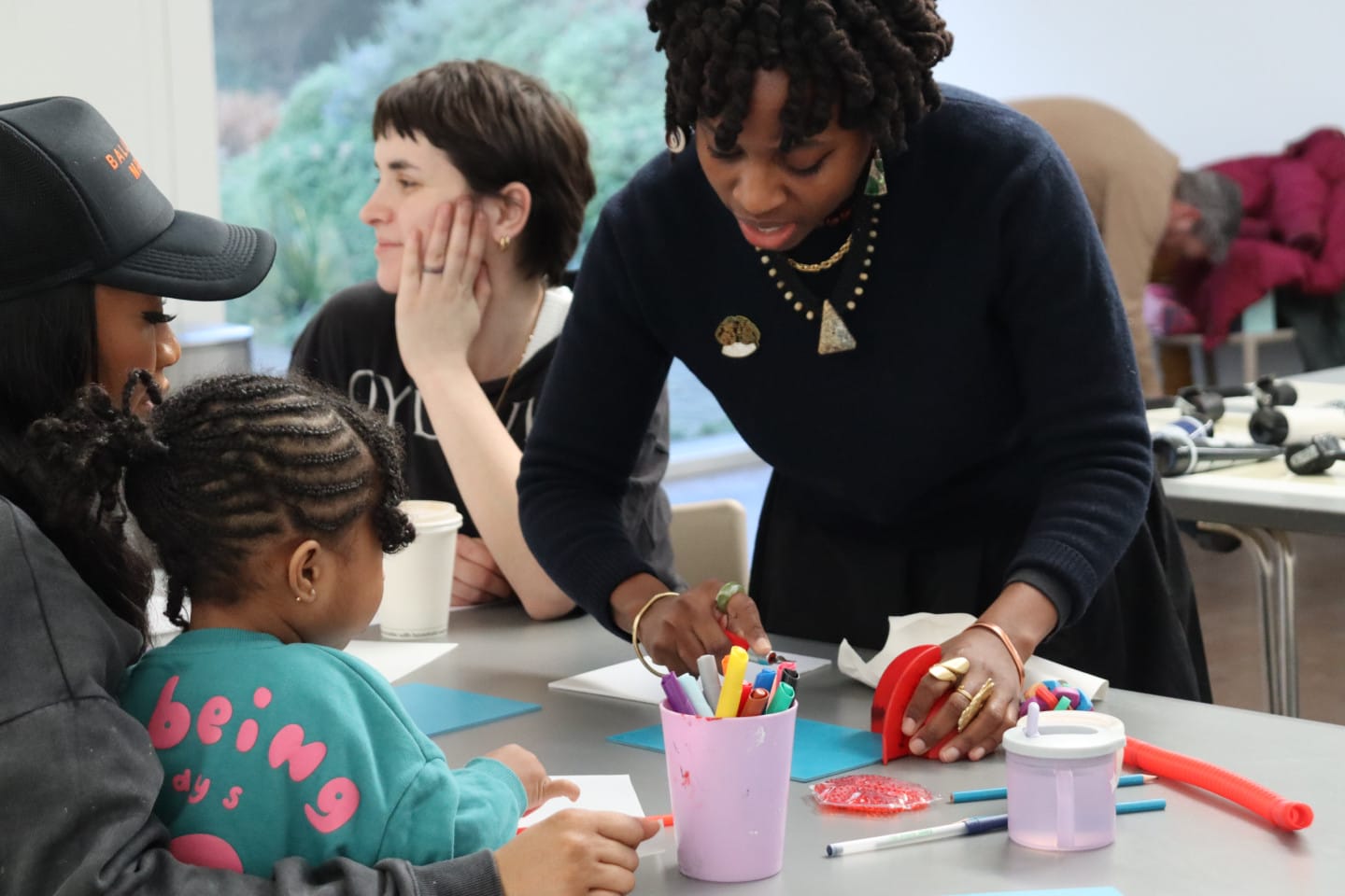 An artist works with a parent and child on creative activities. This is part of the South London Gallery's free family event.