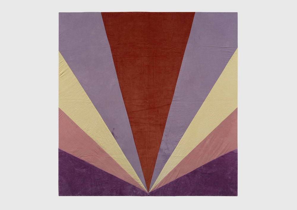 A textile work by artist Yto Barrada. The abstract work consists of several lines coming up and growing out, like rays from a point at the bottom of the canvas.
