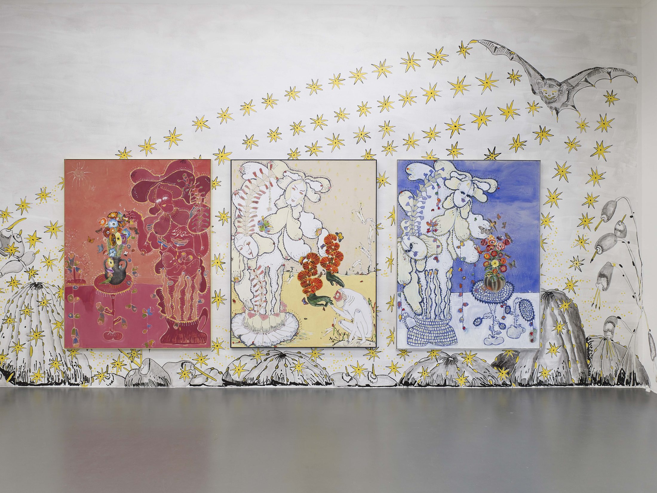 A photograph of a three colourful paintings installed on a wall