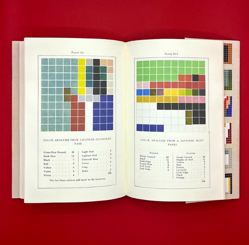 An open book on a red table.