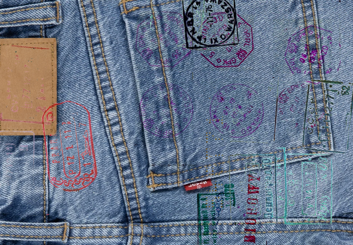 Close-up of denim jeans overlaid with colourful passport-style stamps and travel markings.