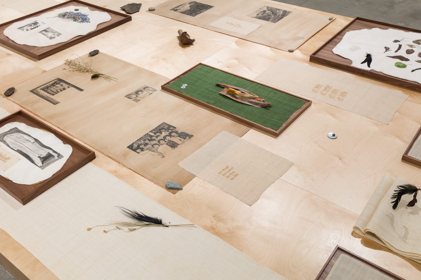 An assortment of woven paper with images, plants and buttons on top.